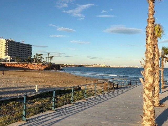 Strandpromenaden västerut, från Zenía Beach räknat till höger, börjar stenbelagd för att en bit bort övergå till trampad jord längs med det röda berget. Bilden tagen en tidig kväll i december när solen börjat dala. Sanslöst vackert!